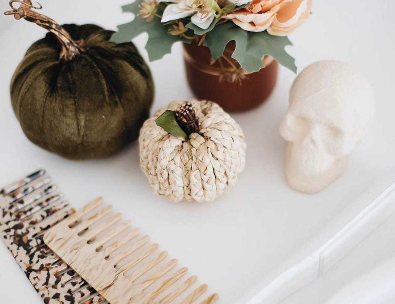 Velvet pumpkins, small skull, and decorative items on a white surface.
